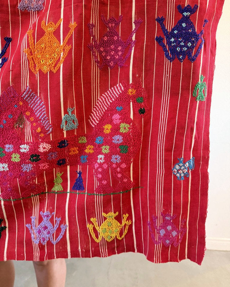 Vintage Guatemalan textile held up outdoors to show its full size